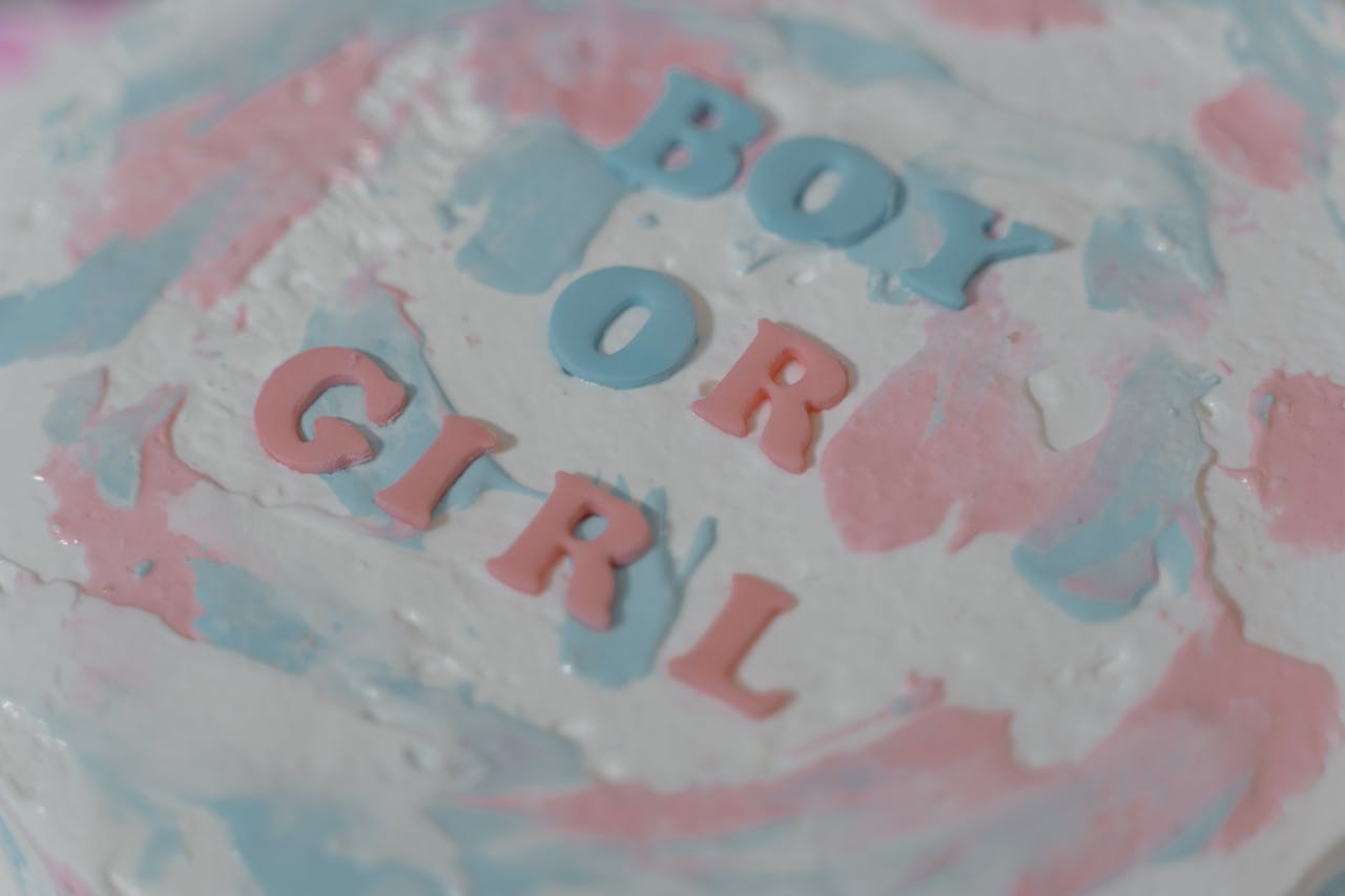 A pastel-colored cake with 'Boy or Girl' text for a gender reveal event.