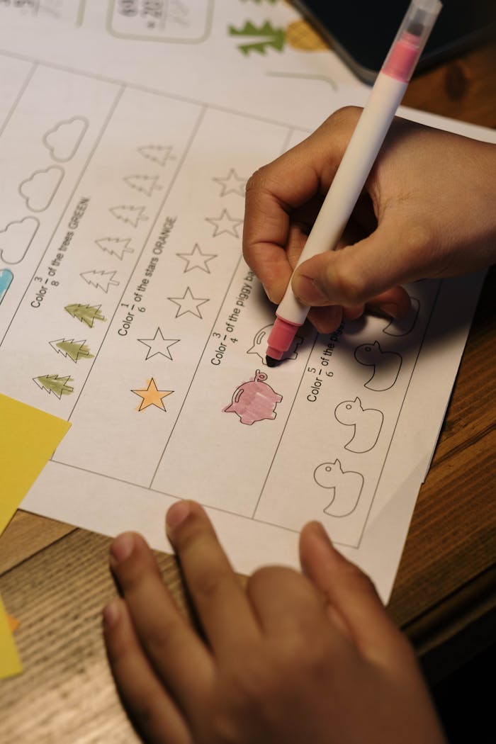 Child coloring shapes as part of a homeschool educational activity indoors with a marker.